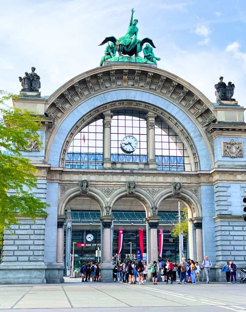 Arch of the railways station with crowd of people in front