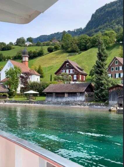 View of Swiss cottages from a boat on Lake Lucerne