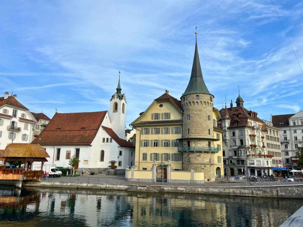 White church with red roof alongside river