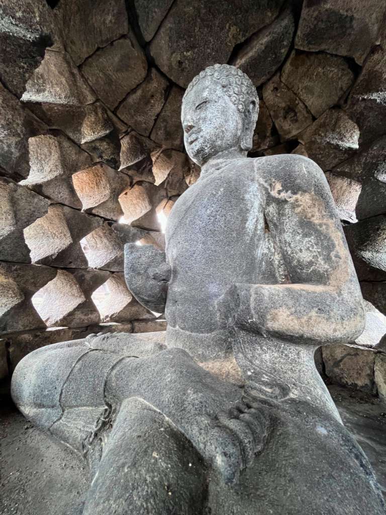 Stone Buddha statue inside a stupa at Borobudur Temple