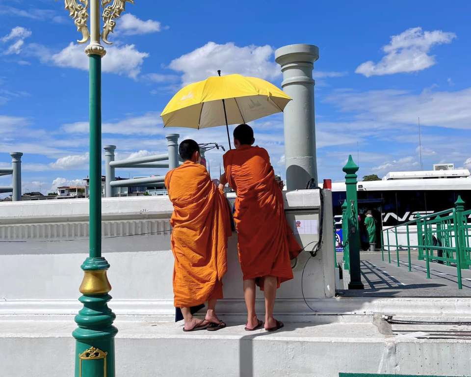 Monks under yellow umbrella in Bangkok